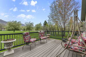 Deck with a mountain view and a lawn