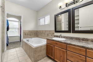 Full bathroom featuring tile patterned flooring, a bath, and vanity