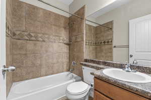 Bathroom with toilet, washtub / shower combination, and vanity