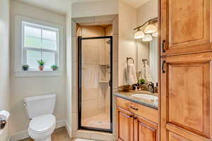 Bathroom with tile patterned flooring, a shower stall, toilet, vanity, and baseboards