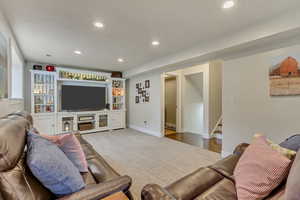 Living room with stairway, wood finished floors, recessed lighting, and baseboards