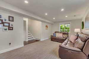 Carpeted living area with recessed lighting, visible vents, stairway, and baseboards