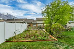 View of yard featuring a mountain view, a fenced backyard, and a vegetable garden