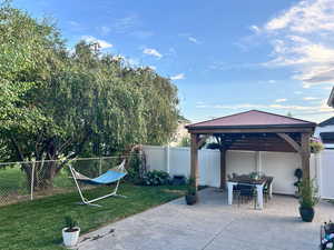 View of patio with a gazebo and a fenced backyard
