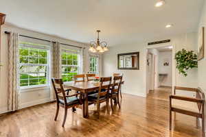 Dining room with a chandelier, baseboards, light wood-type flooring, and recessed lighting