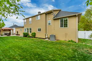 Rear view of property with cooling unit, a patio, a gazebo, a gate, and a yard