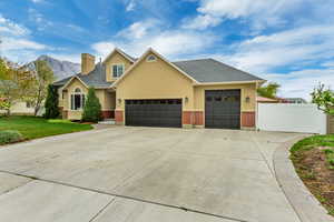 Craftsman-style home featuring brick siding, stucco siding, driveway, and an attached garage