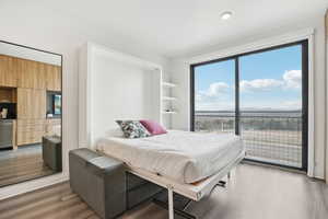 Bedroom with light wood-type flooring, recessed lighting, and access to outside