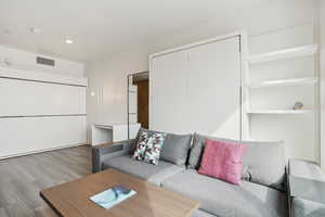 Living area featuring recessed lighting, visible vents, and wood finished floors