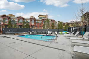 Pool with fence, a patio, and a hot tub