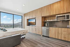 Living room with recessed lighting, wet bar, and light wood-type flooring