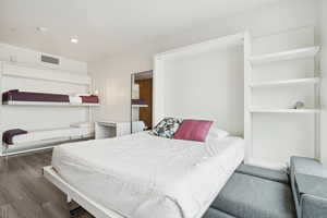 Bedroom with wood finished floors and visible vents