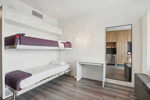 Bedroom with wood finished floors and visible vents