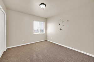 Spare room with carpet and baseboards