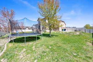 View of yard featuring a fenced backyard and a trampoline