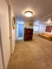 Corridor featuring carpet flooring and a textured ceiling