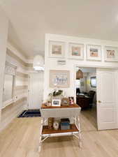Foyer entrance with baseboards, a chandelier, and light wood-style floors