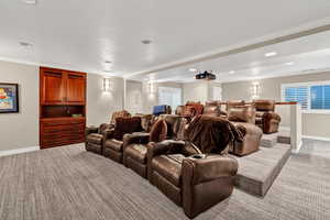 Cinema with ornamental molding, baseboards, recessed lighting, and light colored carpet