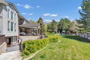 View of yard featuring fence, a deck with mountain view, and a playground