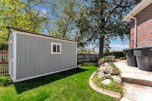 View of yard with fence private yard, an outbuilding, and a shed
