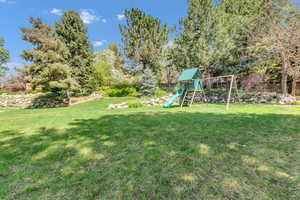 View of yard featuring fence and a playground