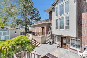 Deck featuring an outbuilding, a storage shed, and stairs