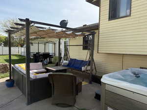 View of patio / terrace with an outdoor living space, fence, a hot tub, and a pergola