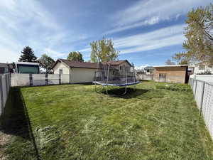 View of yard featuring a fenced backyard and a trampoline