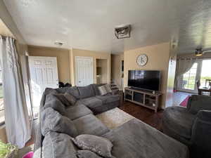 Living area featuring a textured ceiling, wood finished floors, and stairway