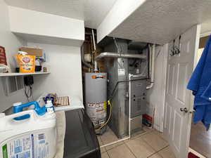Utilities featuring heating unit, water heater, and washing machine and dryer