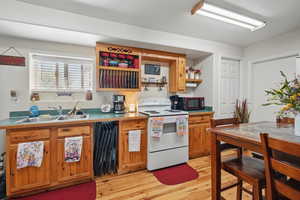Kitchen with open shelves, brown cabinets, a sink, light wood-type flooring, and white electric range
