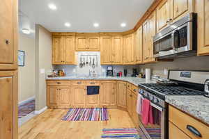 Kitchen featuring baseboards, recessed lighting, stainless steel appliances, and light wood finished floors