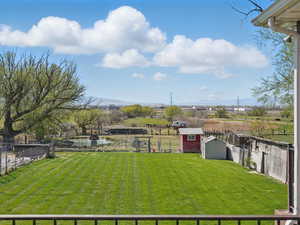 View of yard with an outdoor structure, a storage unit, and a fenced backyard