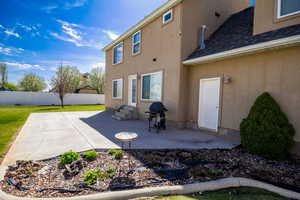 Back of property featuring a patio, fence, entry steps, and stucco siding