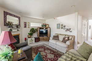Carpeted living area with a glass covered fireplace