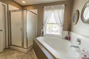 Bathroom with a shower stall and a garden tub