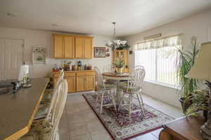 Dining area featuring light tile patterned floors and an inviting chandelier