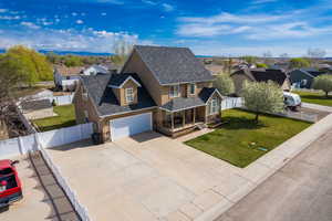 View of front of home with stucco siding, covered porch, a residential view, driveway, and a front lawn