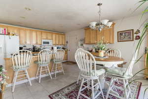 Dining space featuring light tile patterned floors and a chandelier