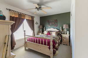 Bedroom featuring visible vents, a ceiling fan, and carpet flooring