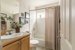 Full bath featuring shower / bathtub combination with curtain, visible vents, toilet, and vanity