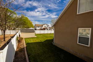 View of yard featuring an outbuilding, a shed, a residential view, and a fenced backyard