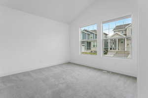 Unfurnished room featuring baseboards, visible vents, carpet floors, and lofted ceiling