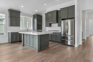 Kitchen featuring appliances with stainless steel finishes, light countertops, and decorative backsplash
