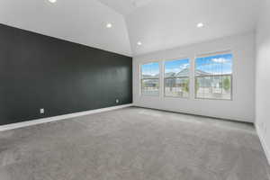 Carpeted empty room with baseboards, recessed lighting, and lofted ceiling