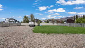 View of yard with a storage shed, an outbuilding, a residential view, and a fenced backyard