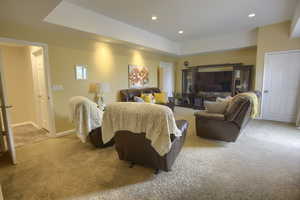 Bedroom featuring recessed lighting, a raised ceiling, carpet, and baseboards