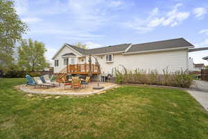 Rear view of property featuring a patio, a wooden deck, stairway, a yard, and fence