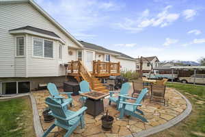 View of patio featuring a deck and a fire pit