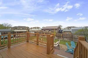 Deck featuring a lawn, a fenced backyard, a residential view, and a patio area